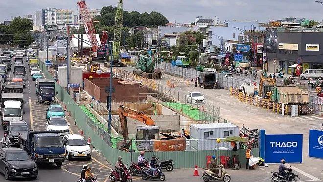 Công trường thi công ga metro số 2 giữa đường đông xe cộ tại TP.HCM, cần cẩu và hàng rào che chắn