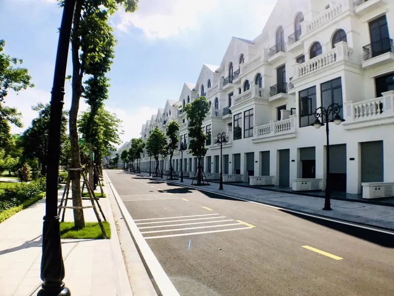 Dãy biệt thự, nhà liền kề màu trắng dọc đường nội khu có cây xanh tại khu đô thị ở Hà Nội
