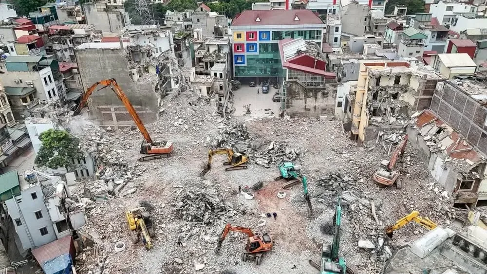 Máy xúc phá dỡ nhà cũ để giải phóng mặt bằng tại một khu vực nội thành Hà Nội nhìn từ trên cao