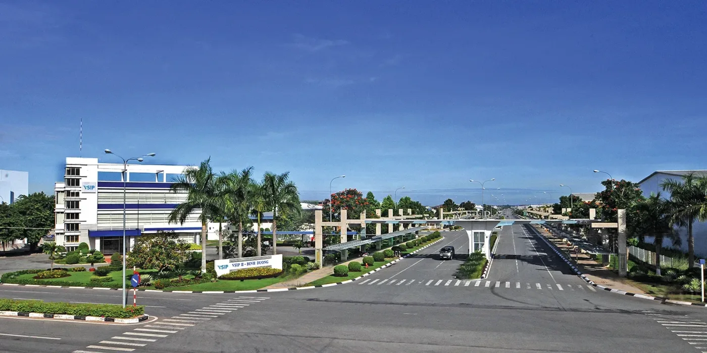 Đường nội khu và cổng khu công nghiệp VSIP tại Bình Dương, hai bên có cây xanh và tòa nhà văn phòng