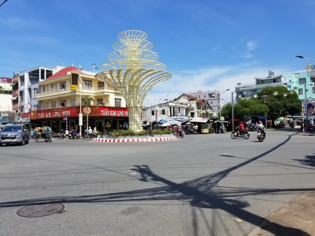Vòng xoay và đường phố khu vực Lái Thiêu, Bình Dương với nhà dân, cửa hàng và xe máy