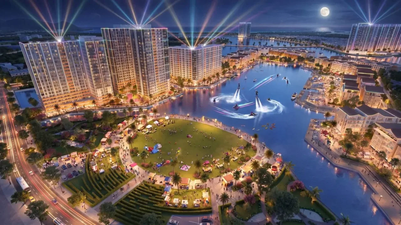 Phối cảnh Festival Island Nam Nha Trang về đêm với hồ sân khấu nước, pháo hoa và các tháp căn hộ ven hồ