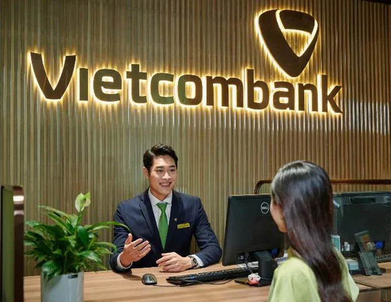 Nhân viên Vietcombank tư vấn khách hàng tại quầy giao dịch, minh hoạ gói vay mua nhà