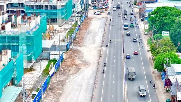 Quốc lộ 13 mở rộng nhiều làn xe chạy, bên trái là công trình đang thi công cạnh dự án