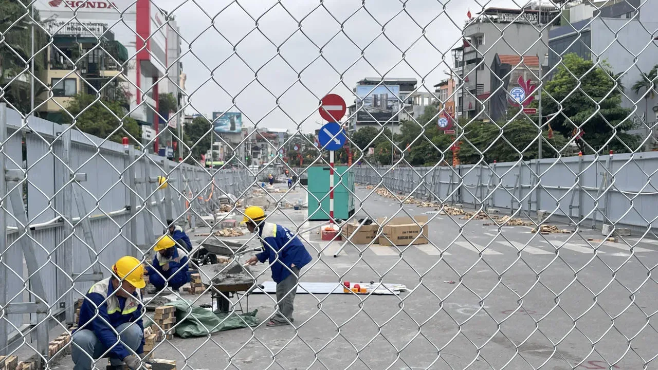 Công nhân thi công sau hàng rào lưới và tôn chắn trên tuyến phố tại Hà Nội