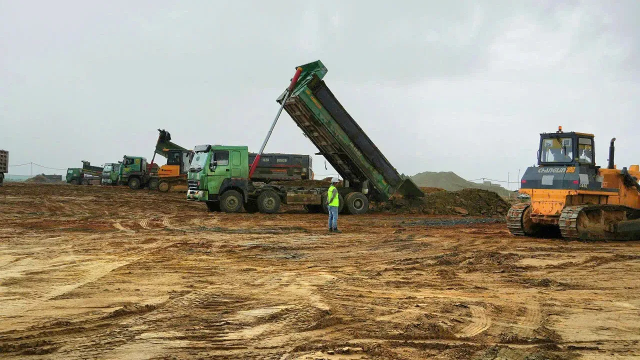 Xe ben đổ đất và máy ủi san lấp mặt bằng tại công trường Khu công nghiệp Vinhomes Vũng Áng, Hà Tĩnh