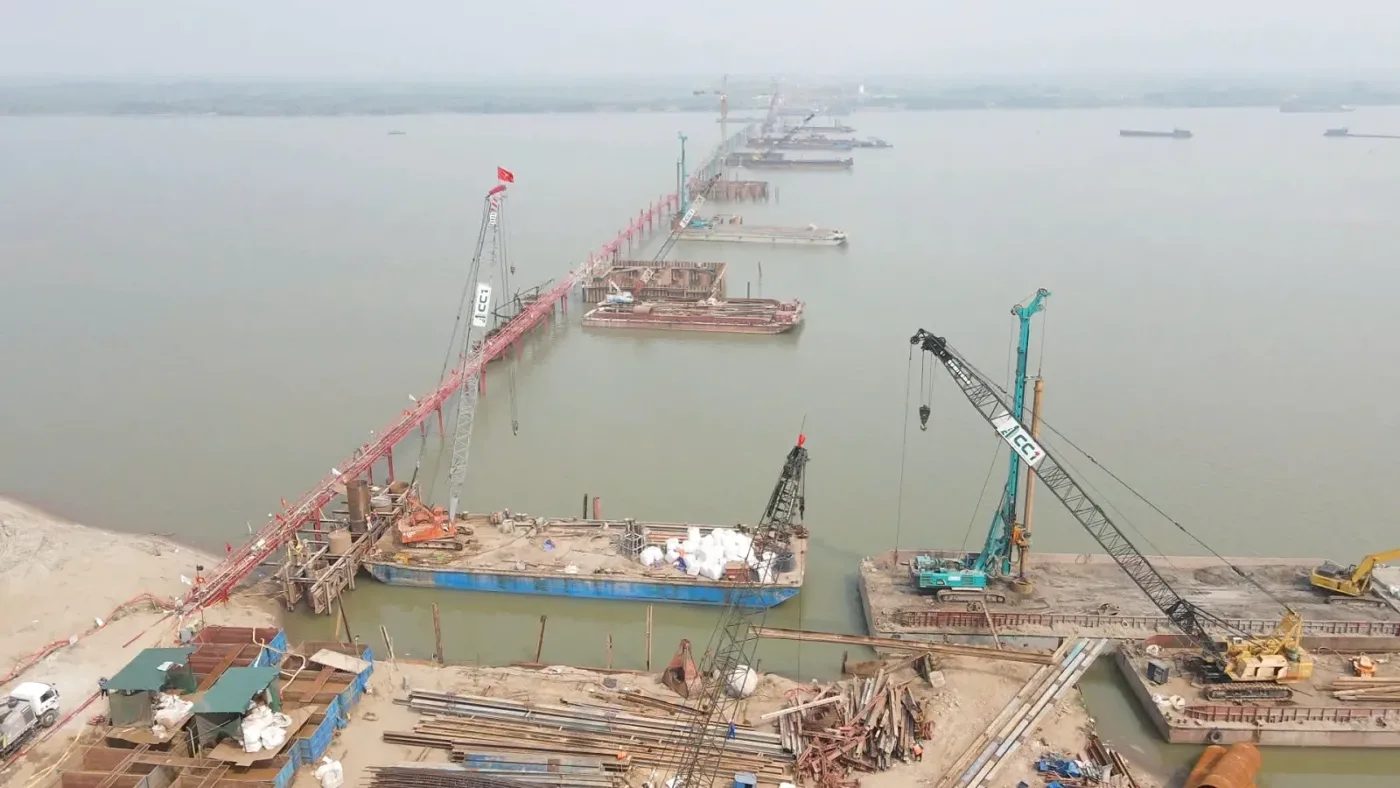Cần cẩu và sà lan thi công trụ cầu Hồng Hà giữa sông Hồng trên tuyến Vành đai 4