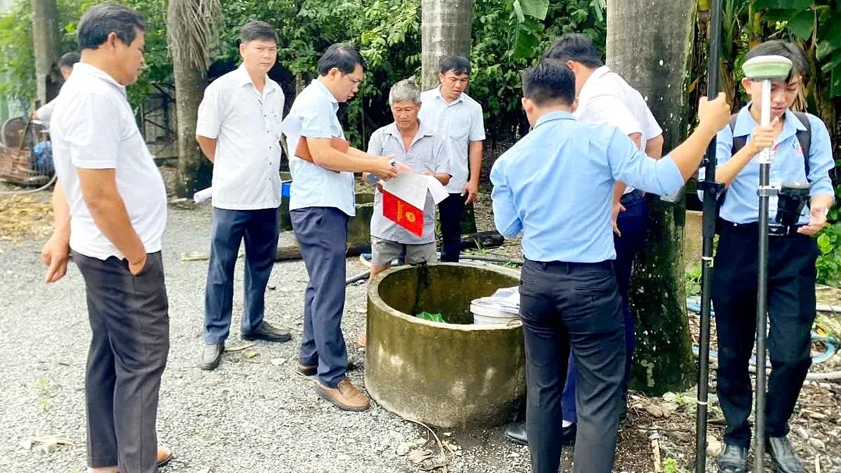 Tổ công tác cùng người dân đo đạc, kiểm đếm đất và tài sản gắn liền với đất cho dự án metro ở Bình Dương