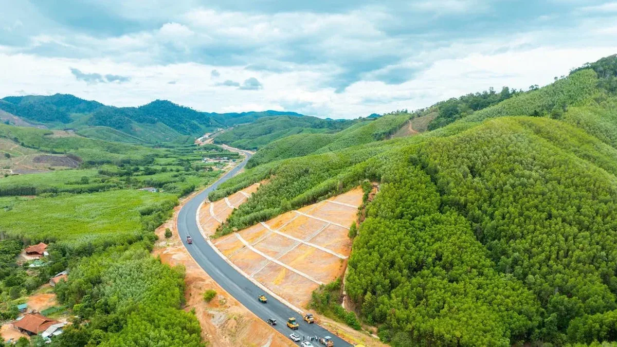 Toàn cảnh đoạn cao tốc Khánh Hòa – Buôn Ma Thuột đã trải nhựa, chạy giữa đồi rừng, xe thi công trên mặt đường