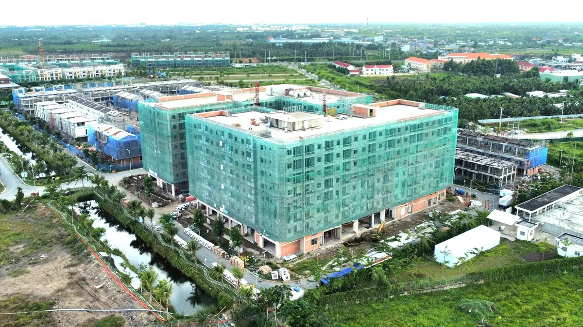Toàn cảnh khu nhà ở xã hội đang thi công với tòa nhà phủ lưới xanh nhìn từ trên cao