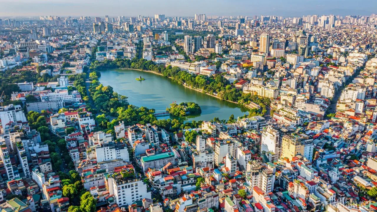 Toàn cảnh hồ Hoàn Kiếm và Tháp Rùa nhìn từ trên cao giữa các khu phố dày đặc nhà cửa ở Hà Nội