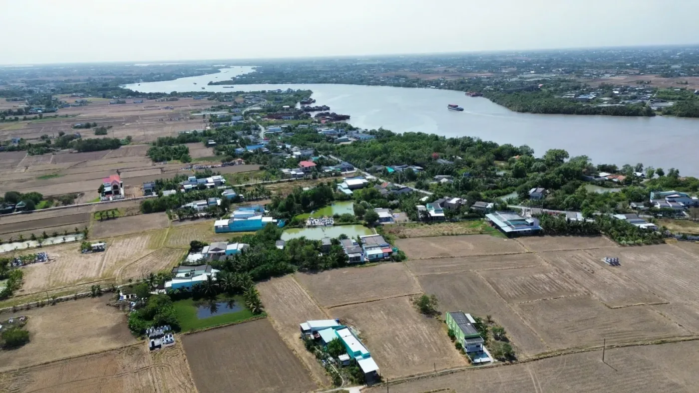 Toàn cảnh khu vực ven sông tại xã Long Hựu nhìn từ trên cao, nhà dân xen đất nông nghiệp và cây xanh