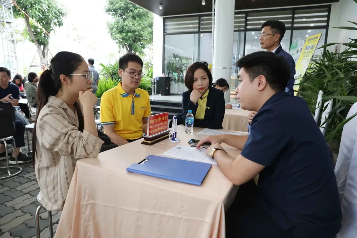 Người dân ngồi trao đổi, nộp hồ sơ với cán bộ tại bàn tư vấn mua nhà ở xã hội