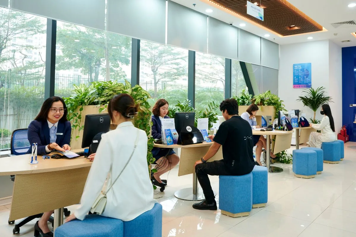 Nhân viên ngân hàng tư vấn khách hàng vay mua nhà tại quầy giao dịch